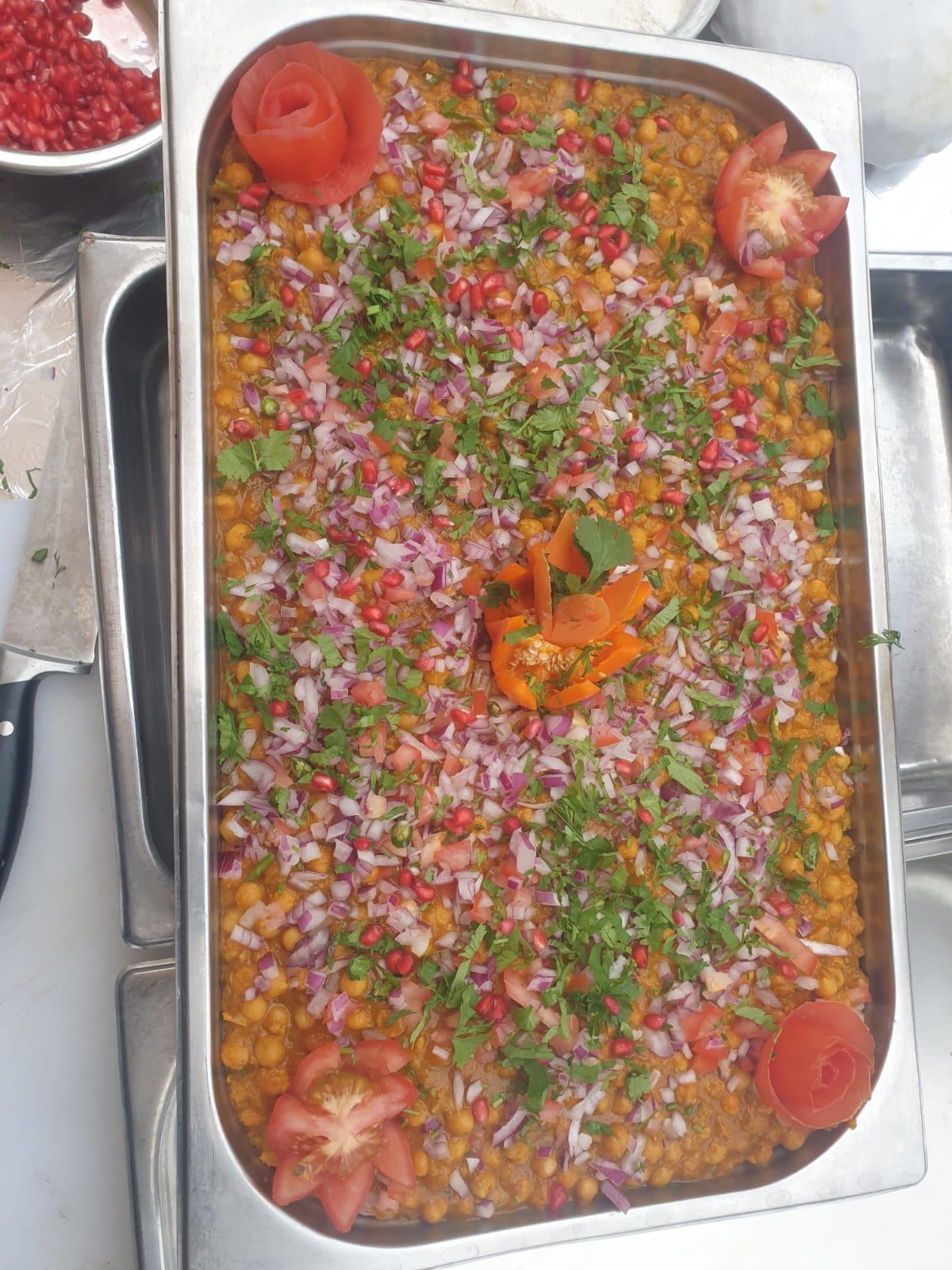 Chana masala tray garnished with pomegranate and onion