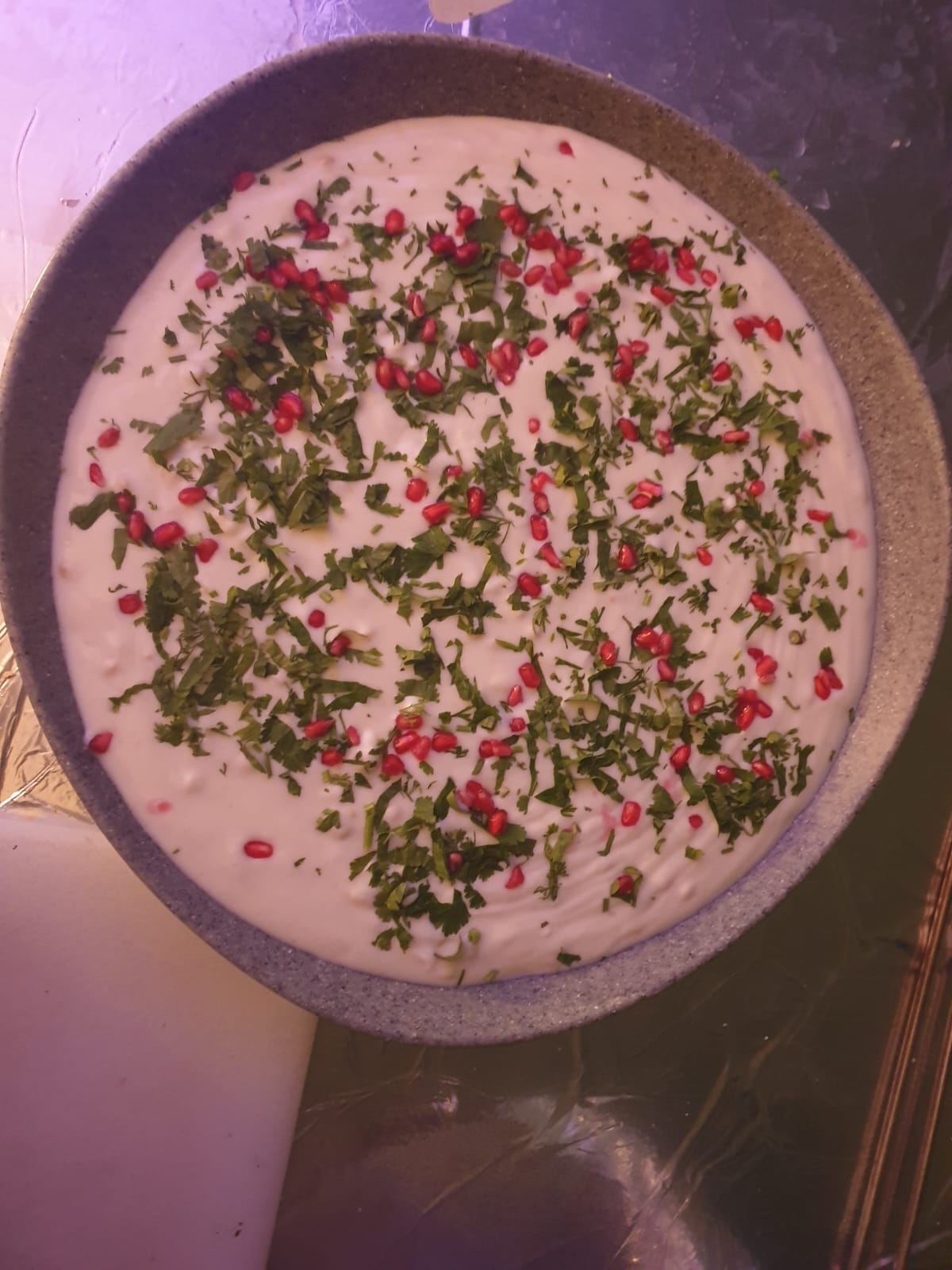 Large tray of raita garnished with pomegranate